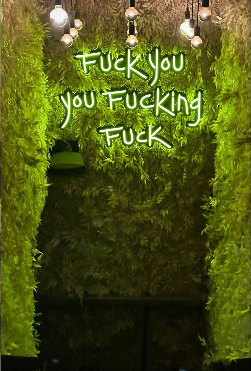 Neon sign at a WeWork or hacker house common area during the startup grind period